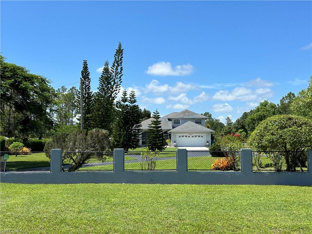 View of home featuring a lawn and fence.