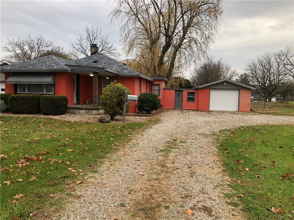 a front view of house with yard and trees in the background