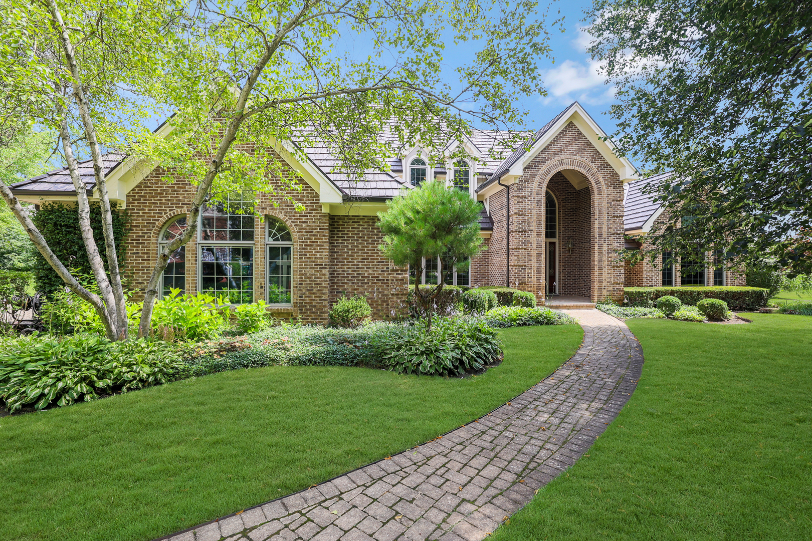 a front view of a house with a garden and yard