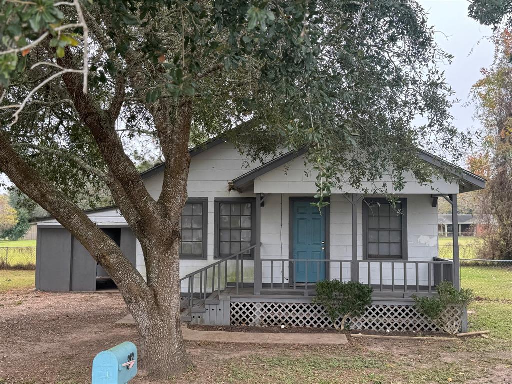 a front view of a house with a tree