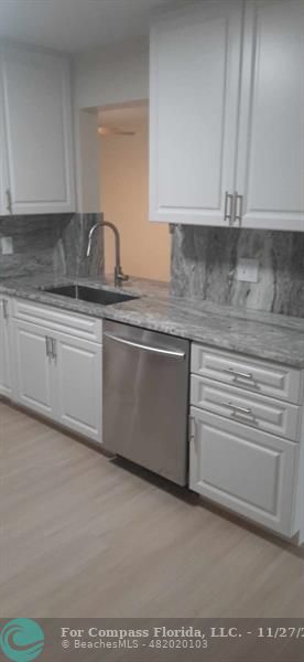 a kitchen with granite countertop a sink and cabinets