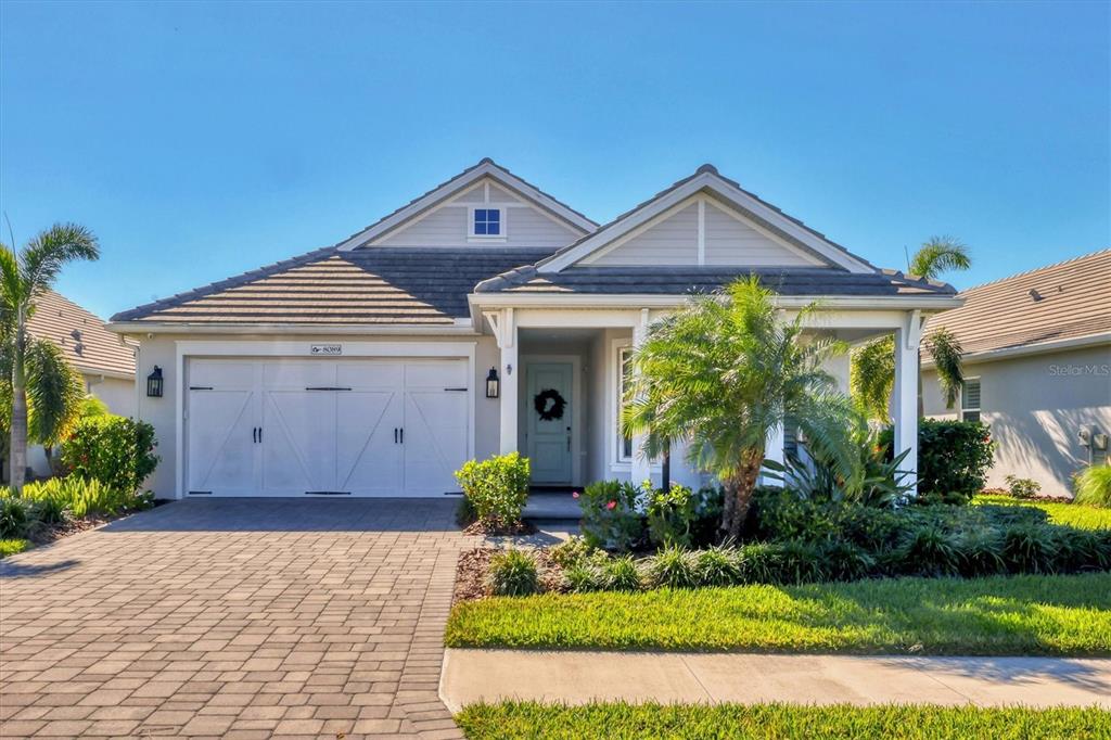 a front view of a house with a yard and potted plants