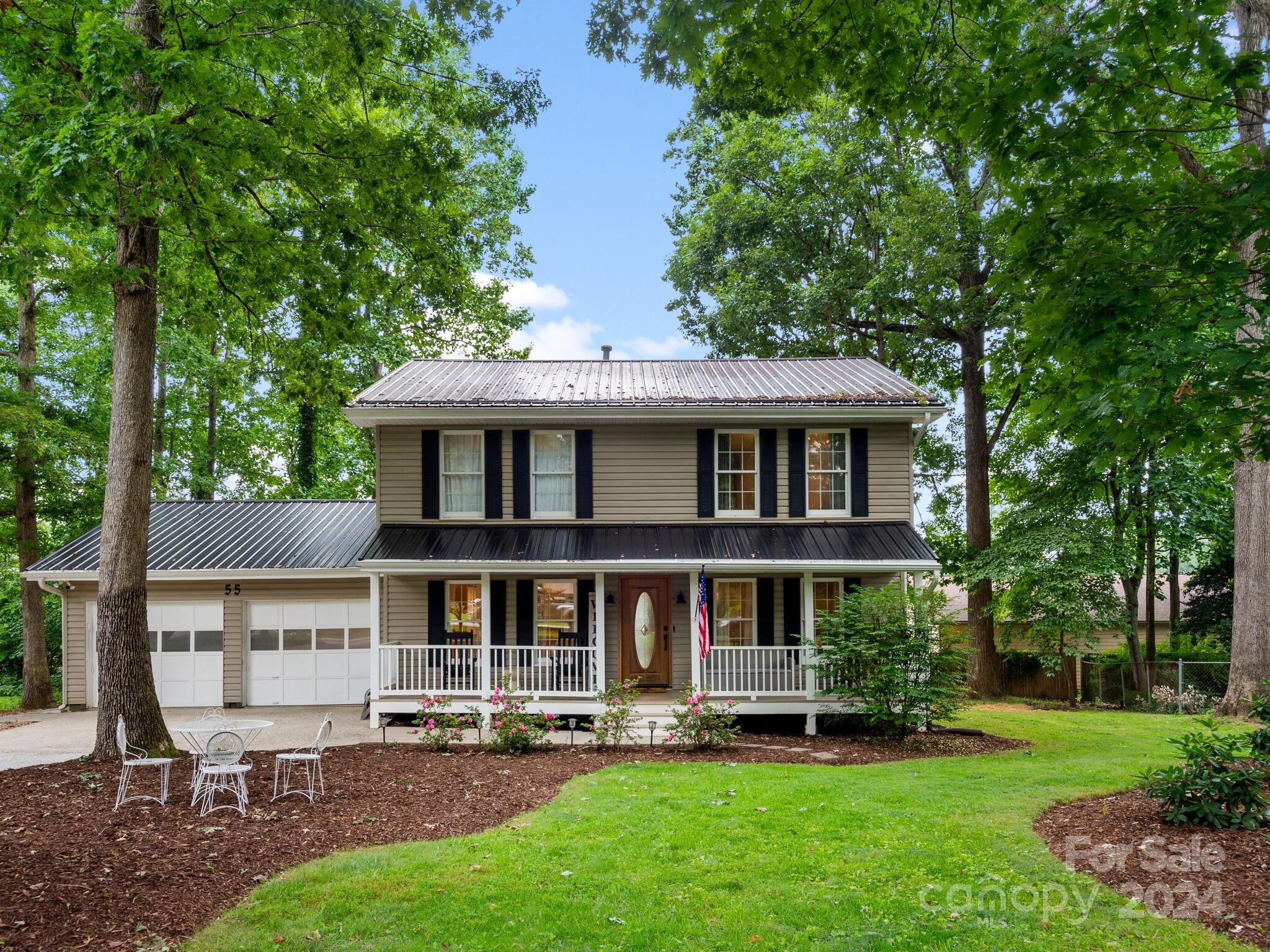 a front view of a house with a garden and trees