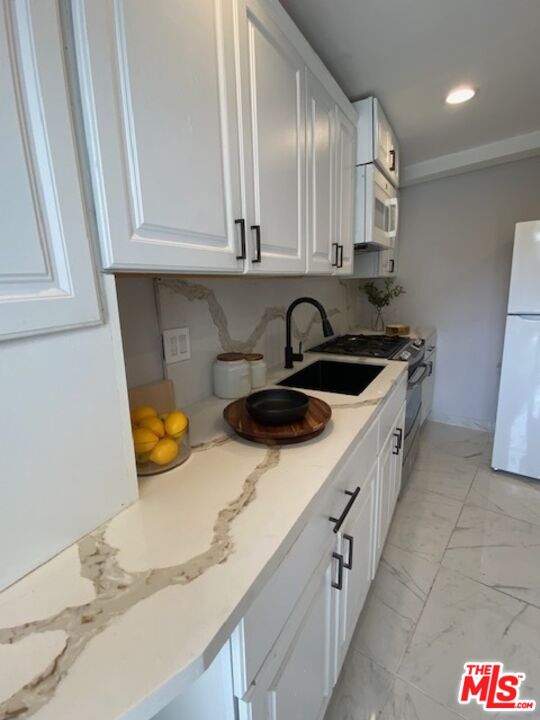 a kitchen with stainless steel appliances granite countertop a sink and cabinets