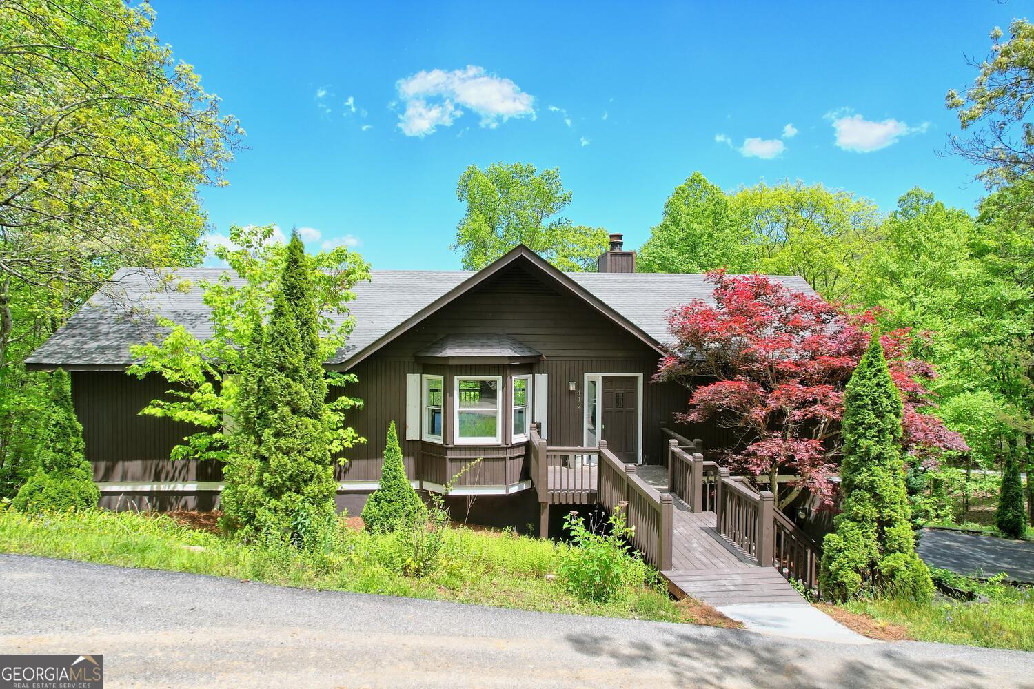 a front view of a house with a yard and potted plants