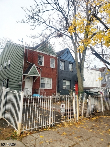 a front view of a house with a tree