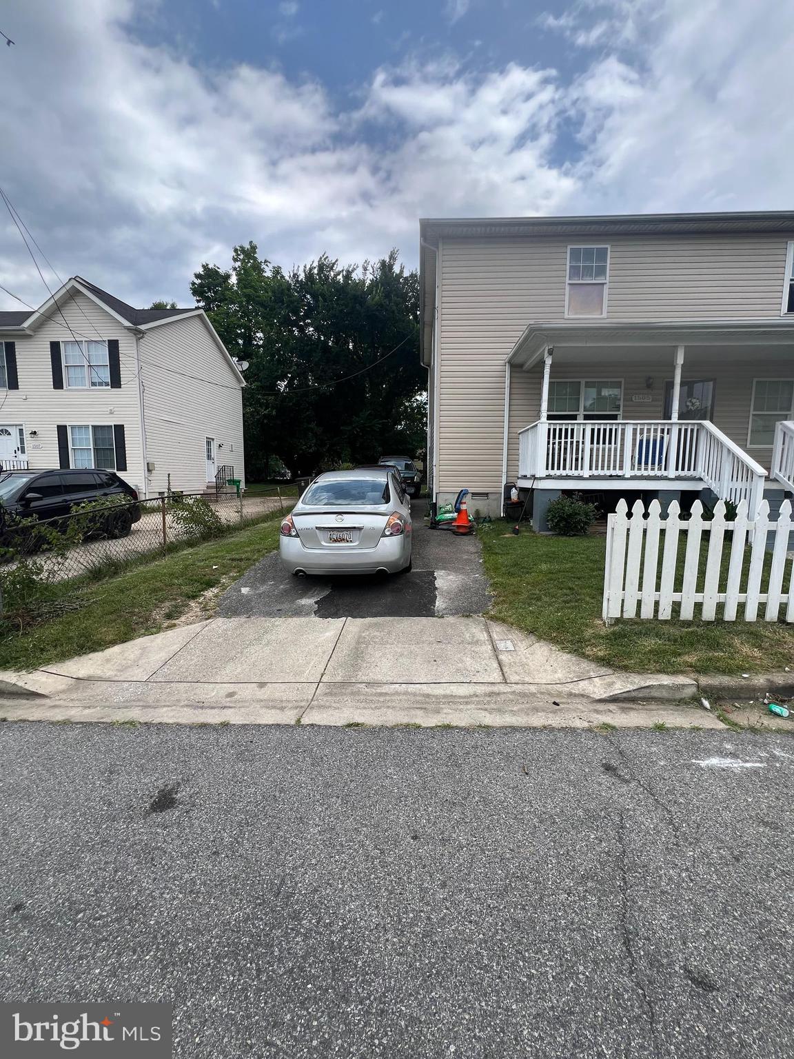 a view of a house with a yard and large parking space