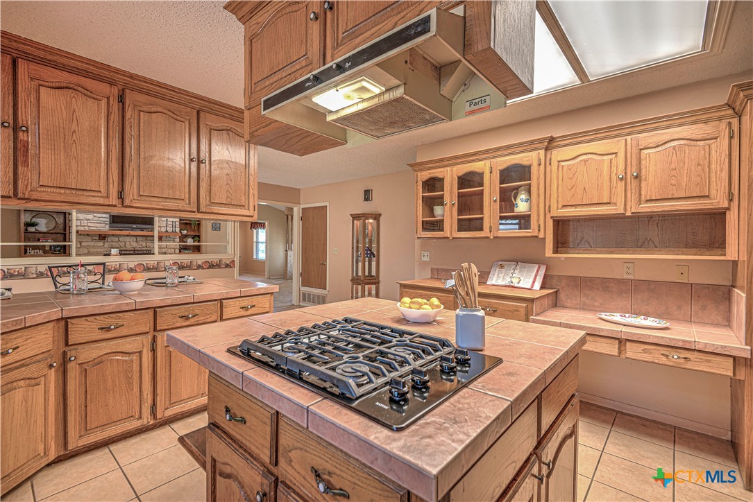 a kitchen with kitchen island granite countertop a sink cabinets and stainless steel appliances