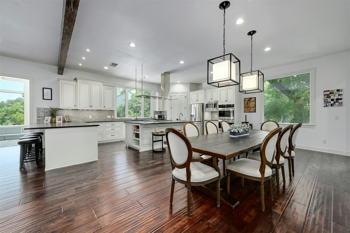 a view of a dining room and livingroom with furniture wooden floor a chandelier