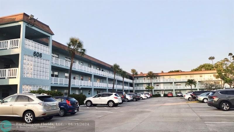 a view of building with cars parked in front of it