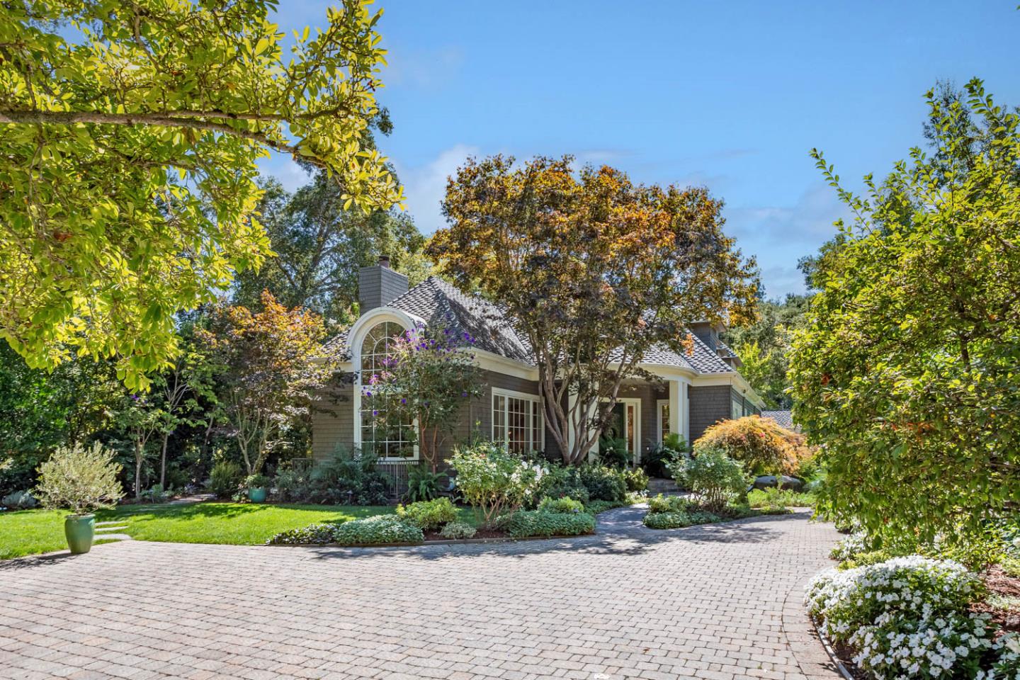 a front view of a house with a yard and a garden