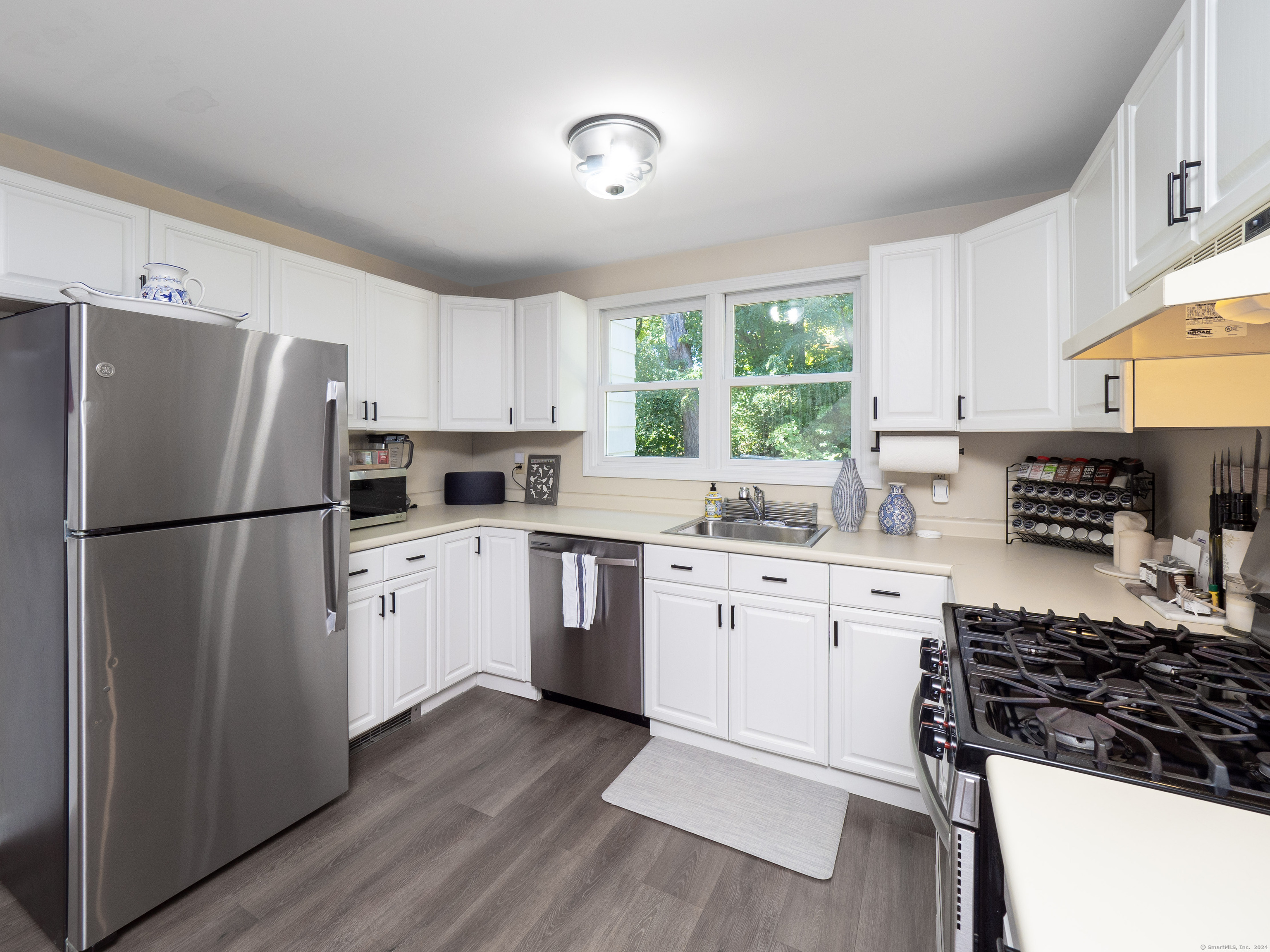 a kitchen with granite countertop a refrigerator stove top oven and sink