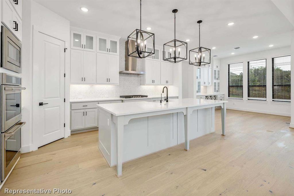 a kitchen with white cabinets and sink