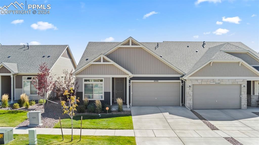 Craftsman-style house featuring a front yard and a garage