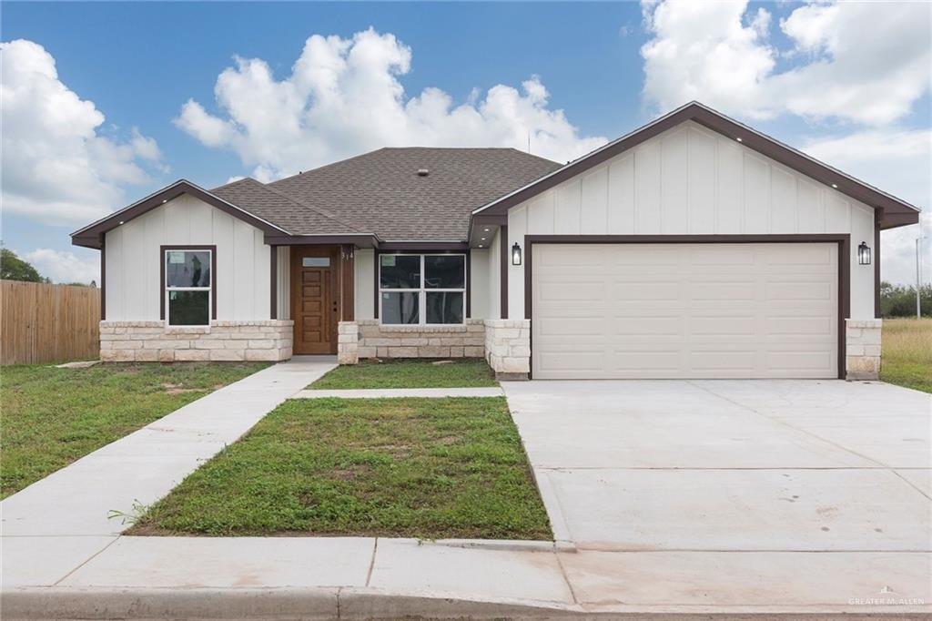 View of front of home with a front yard and a garage