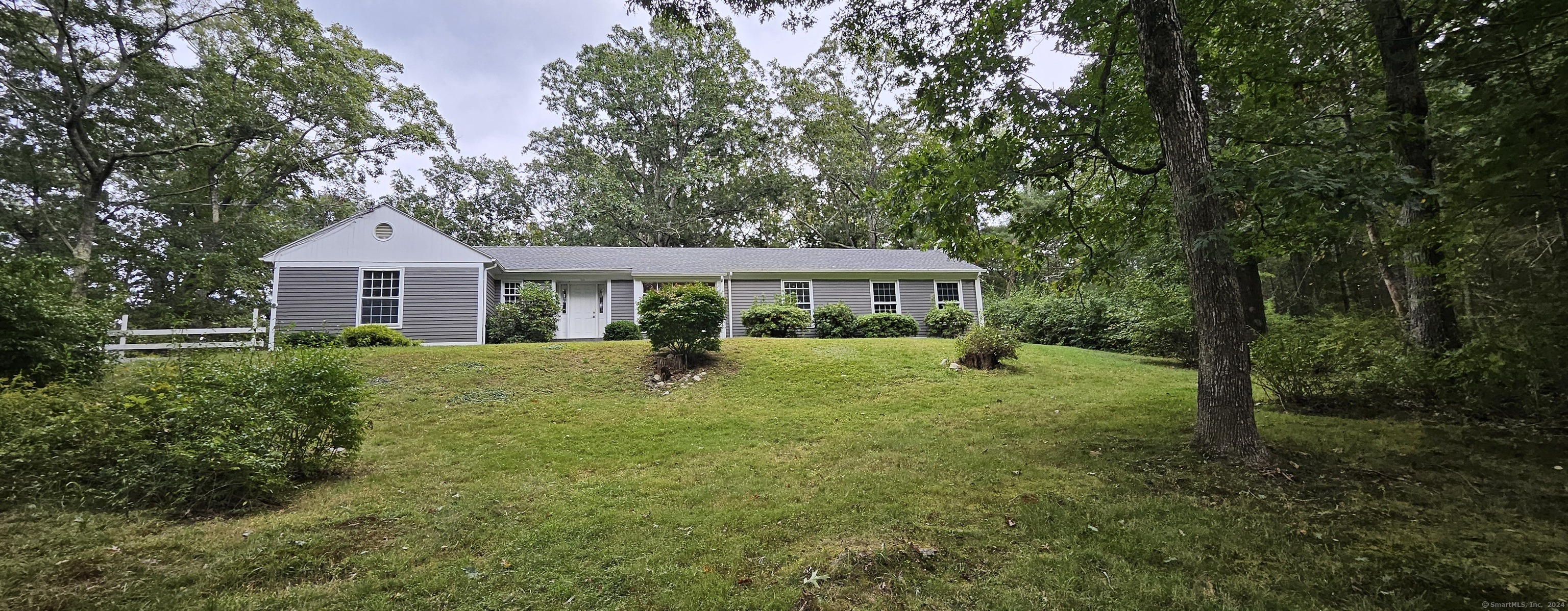 a front view of a house with a yard and trees