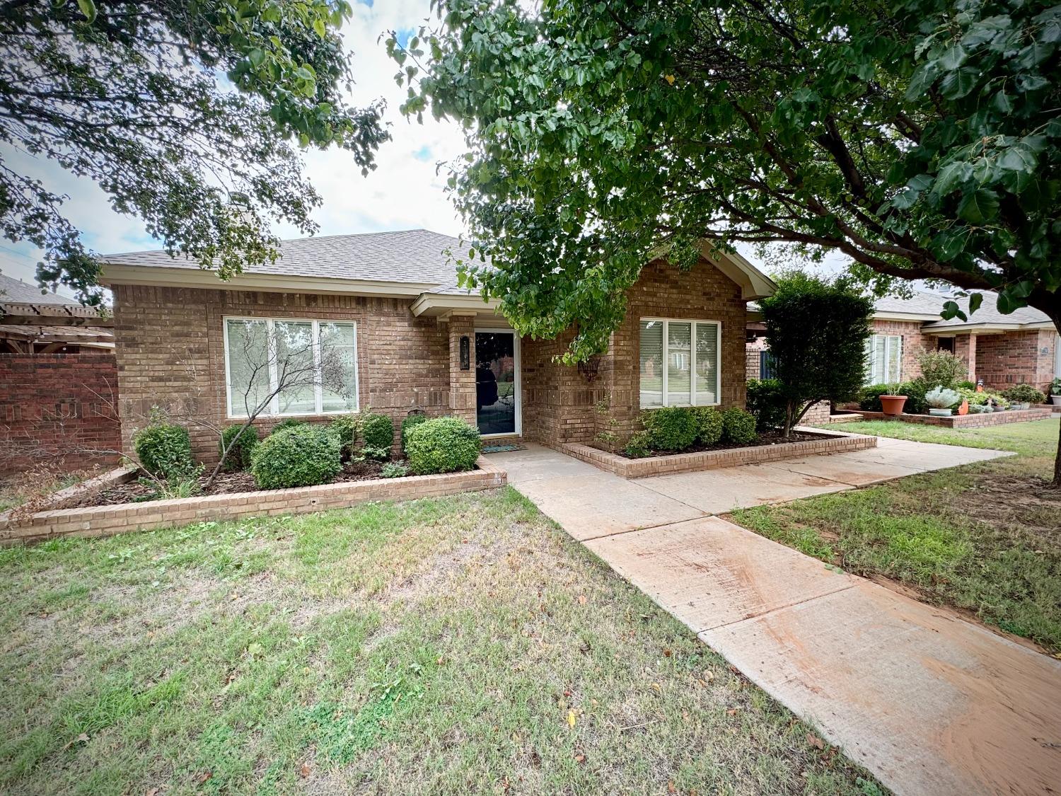 a front view of a house with a yard and potted plants