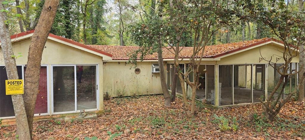 a view of a house with a small yard and a large tree