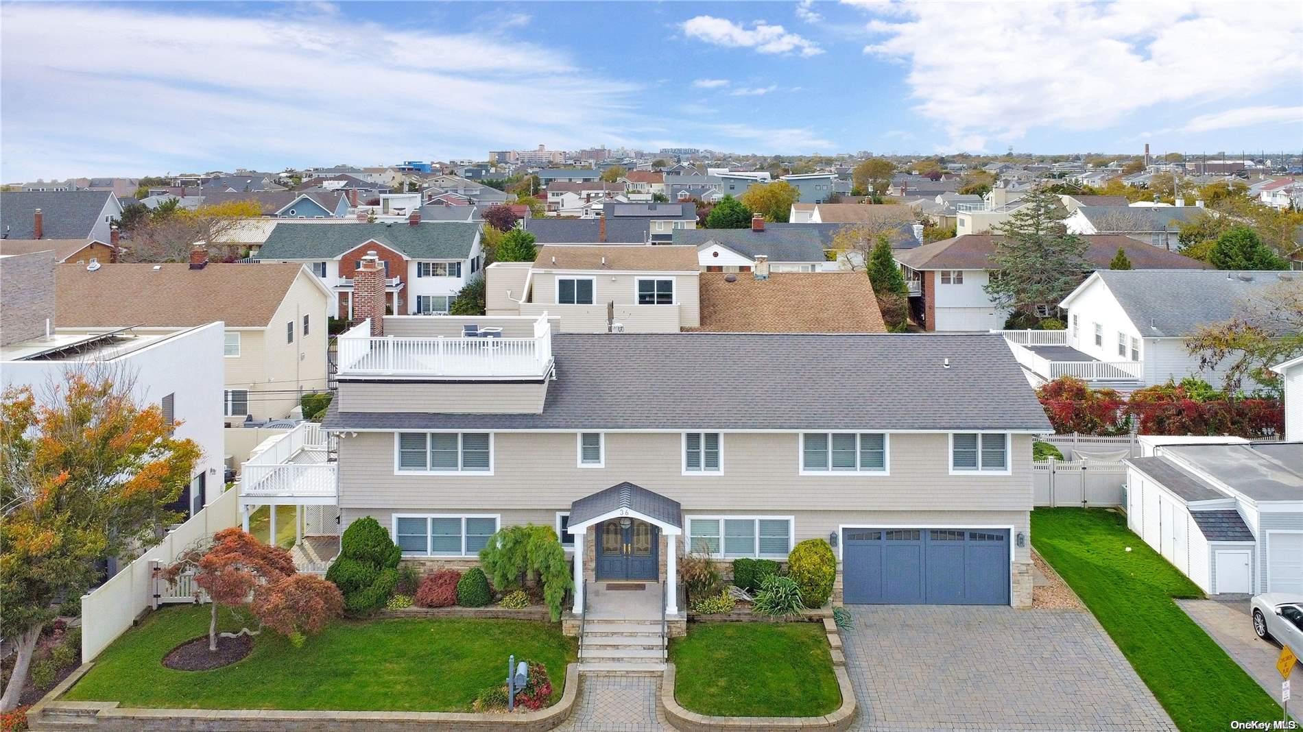 an aerial view of a house with a yard garage and lake view