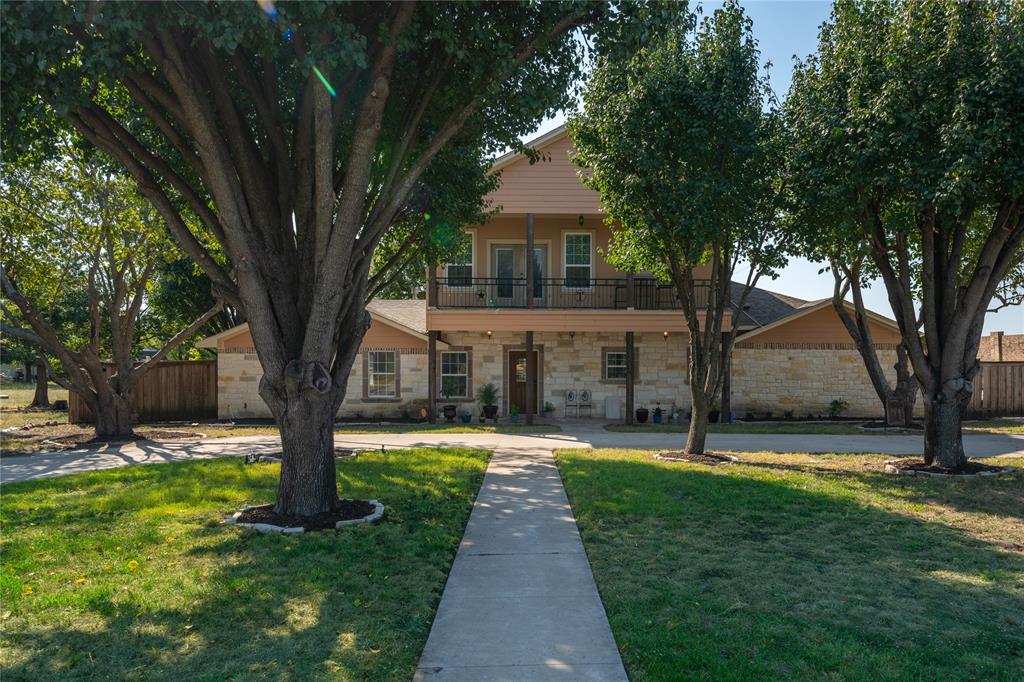 a front view of a house with a yard and tree