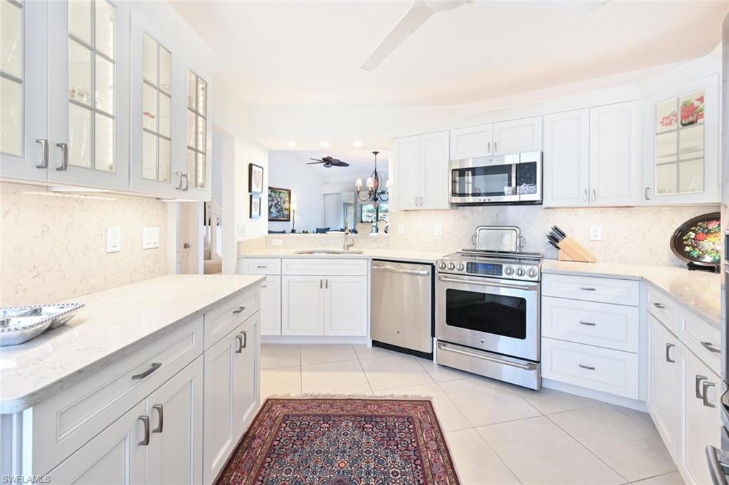 a kitchen with white cabinets and white appliances