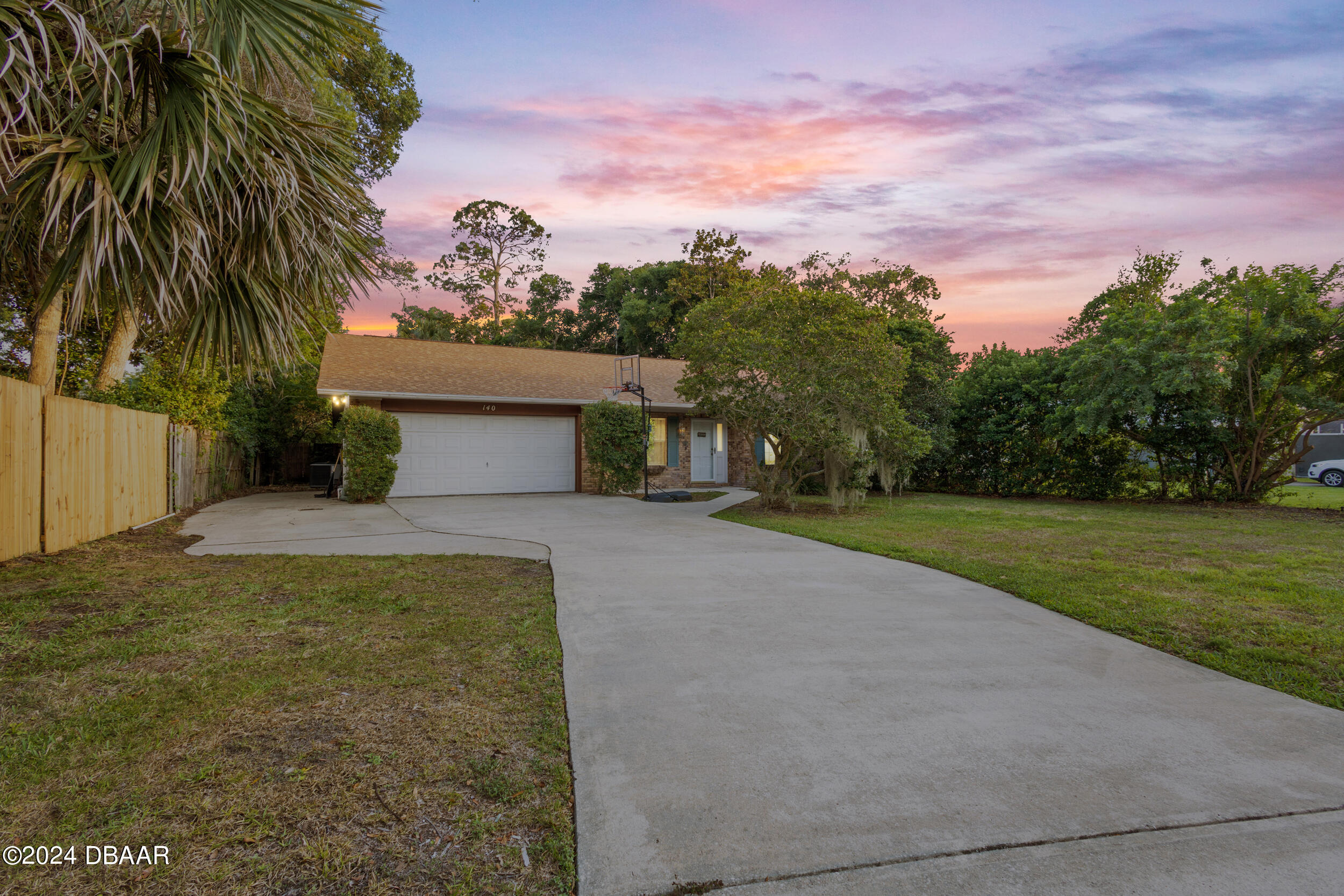 a view of a house with a yard and palm trees