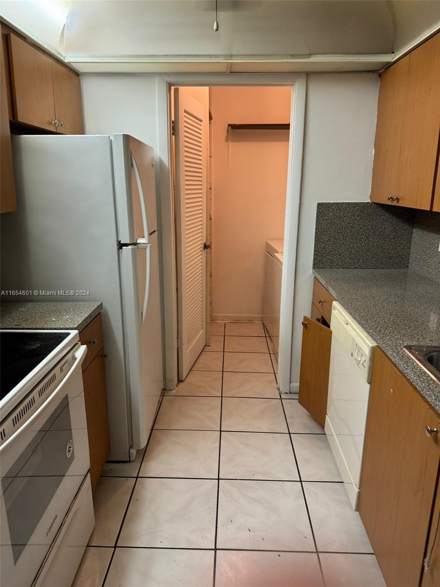 a kitchen with a refrigerator sink and cabinets