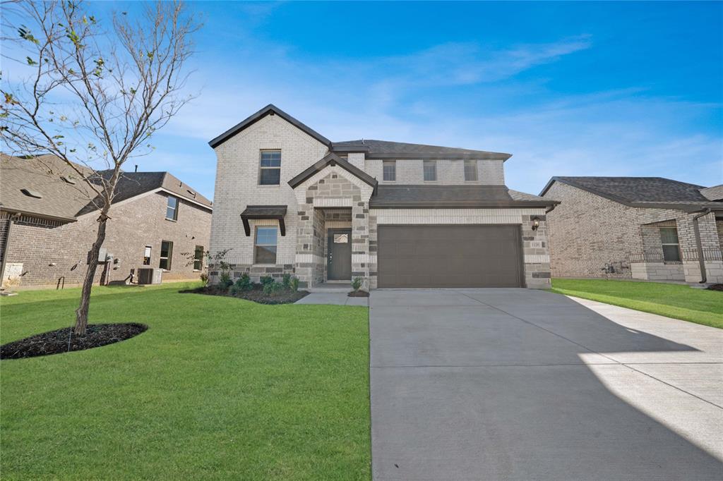 a front view of a house with a yard and garage