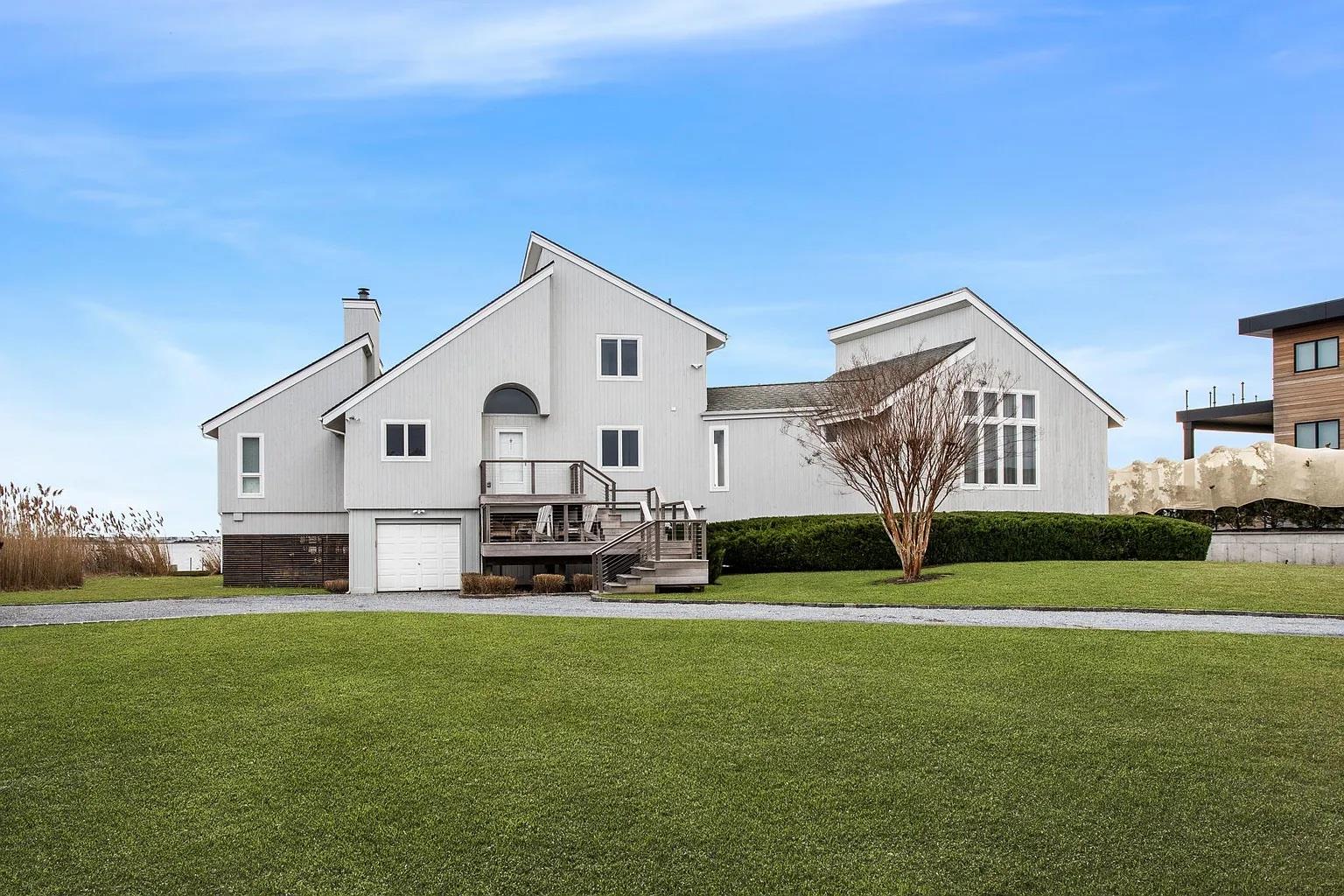 Back of house with a lawn and a garage