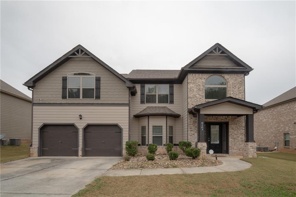 a front view of a house with yard and parking