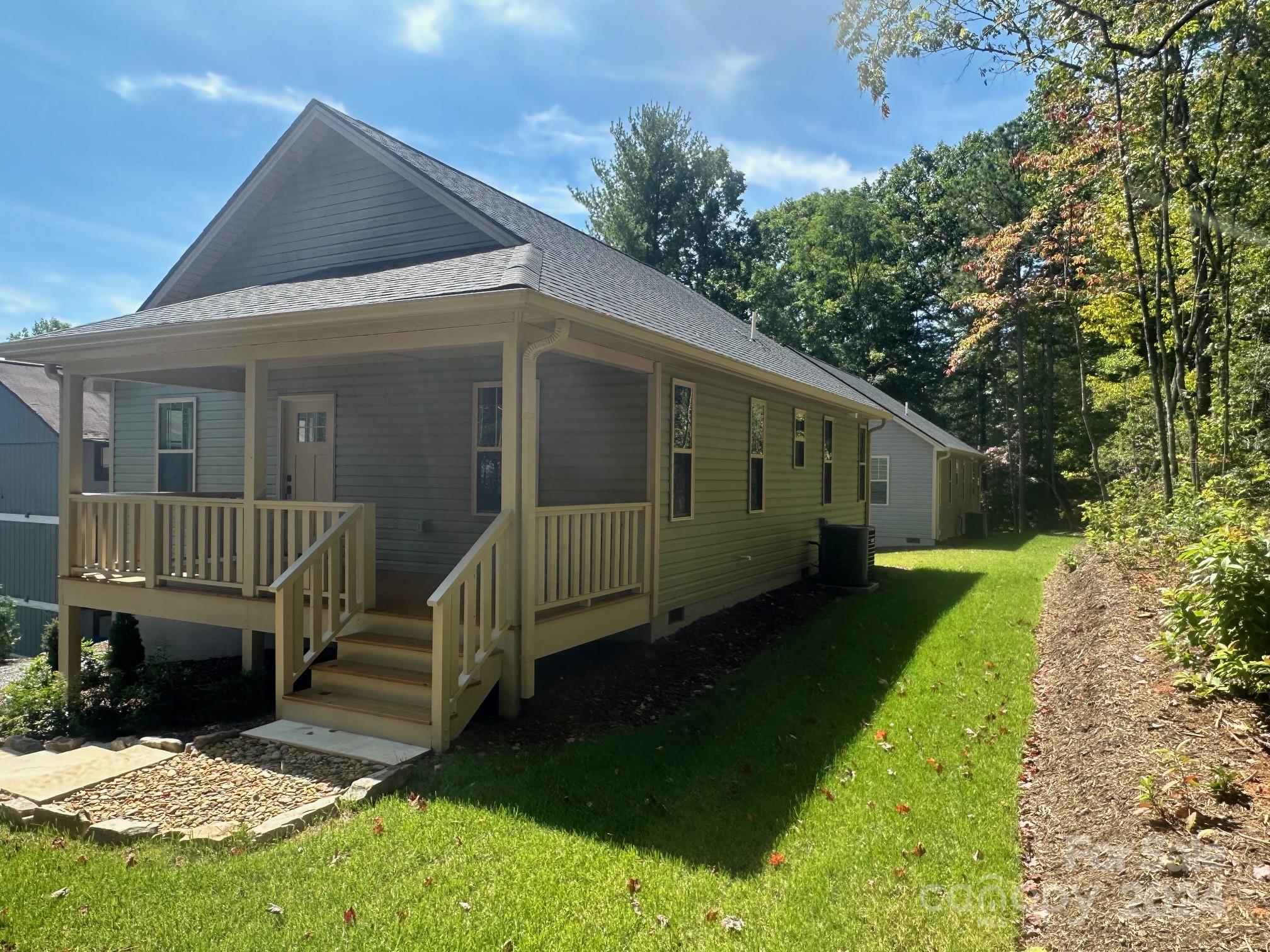 a view of house with a yard and deck