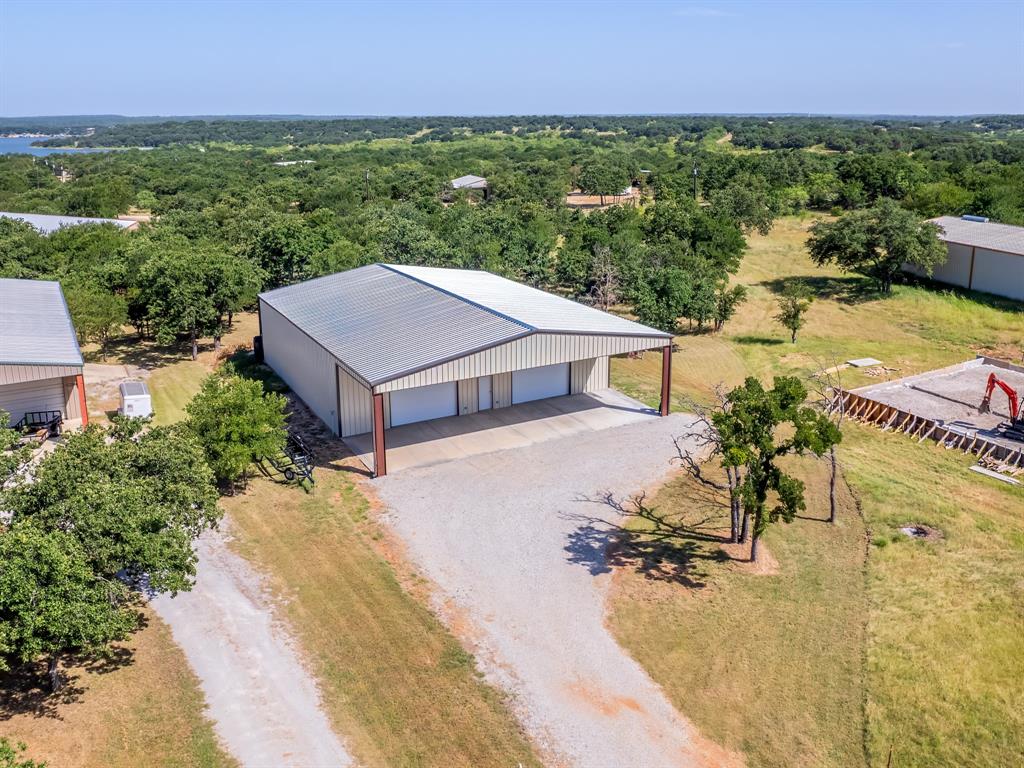 an aerial view of a house with swimming pool and large trees