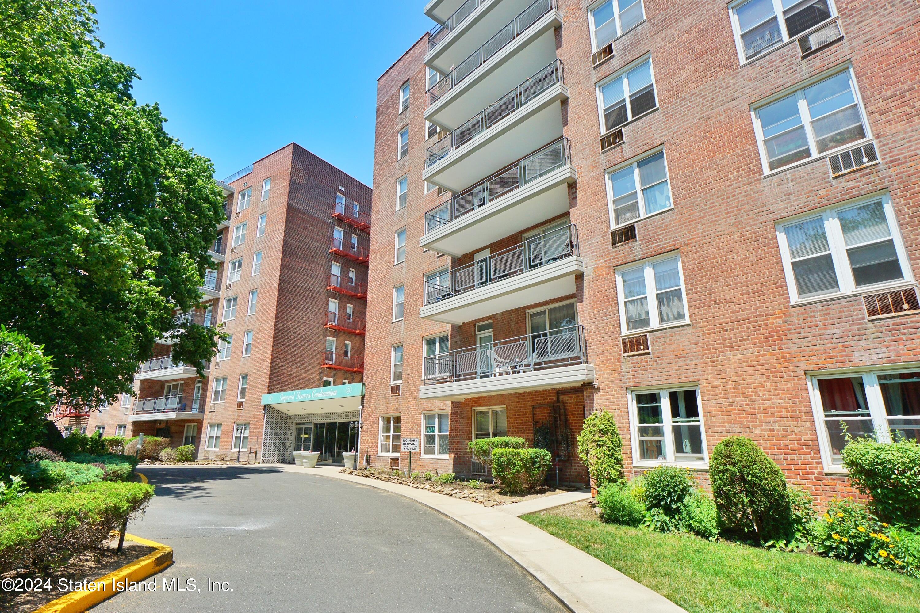 a front view of a multi story building with yard