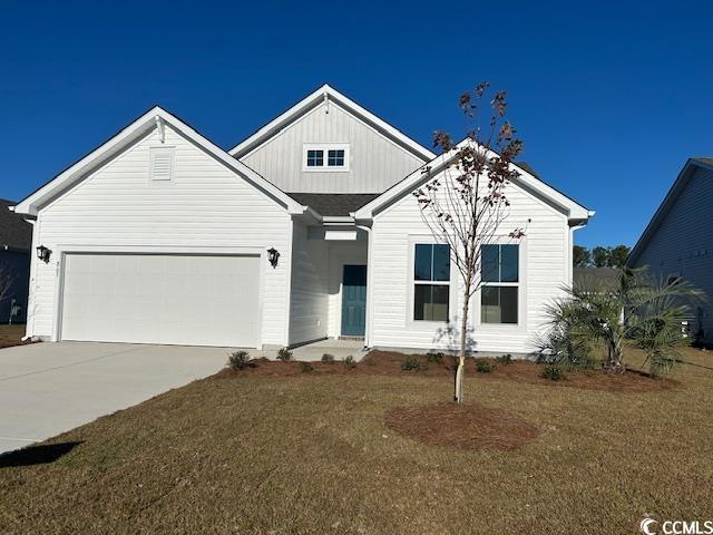 View of front of home with a garage and a front ya