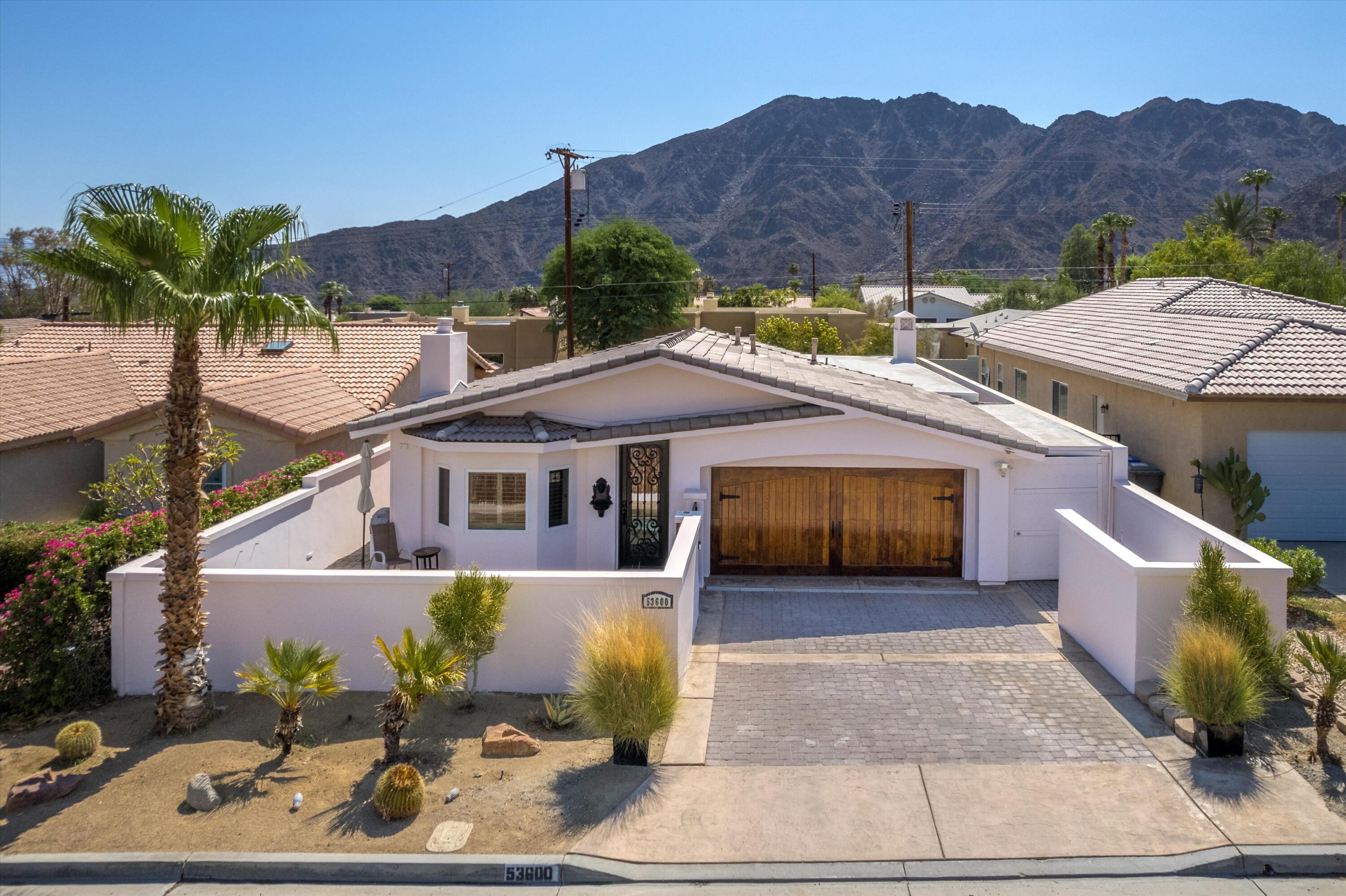 a front view of a house with a yard and mountain view