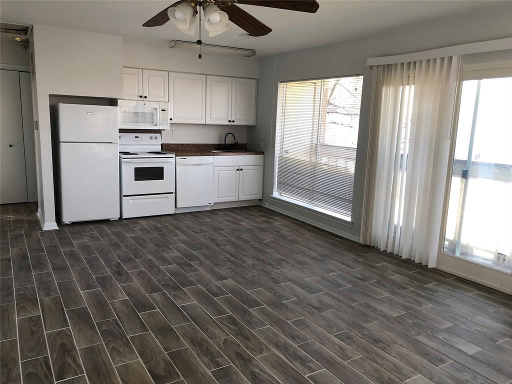 a kitchen with wooden cabinets and white appliances