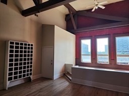 a view of empty room with wooden floor and windows