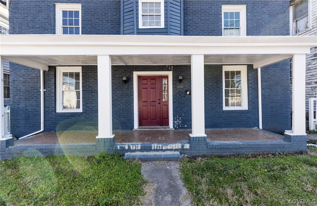 a front view of brick house with a yard