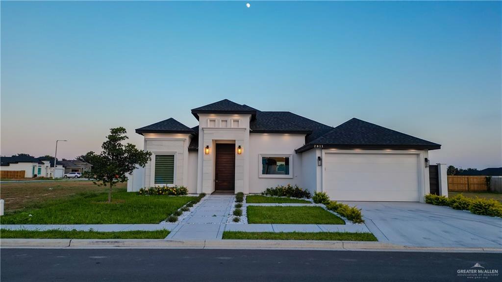 a front view of a house with a yard and garage