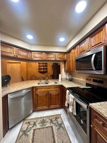 a kitchen with stainless steel appliances granite countertop a stove and a sink