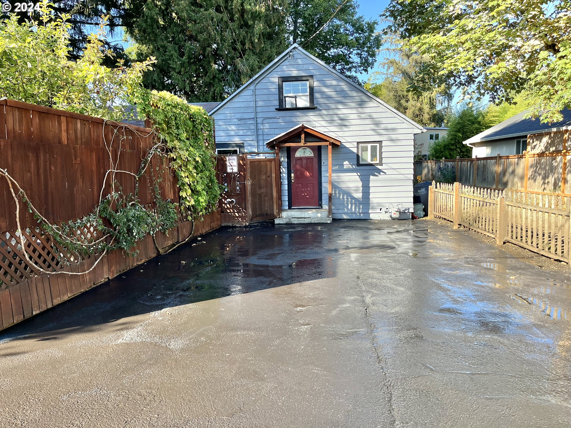 a view of a small house with wooden fence