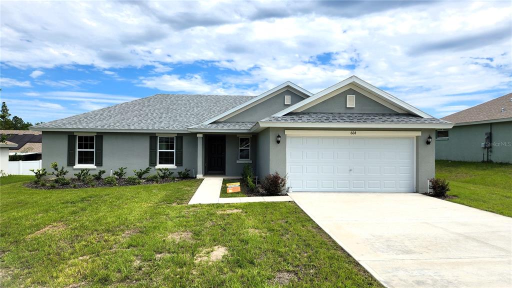 a front view of a house with a yard and garage