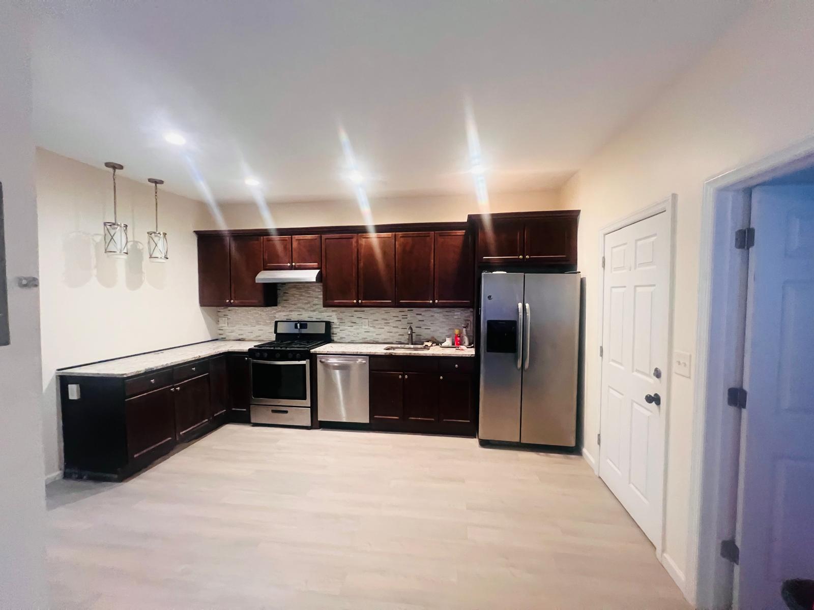 a large kitchen with a stove and refrigerator