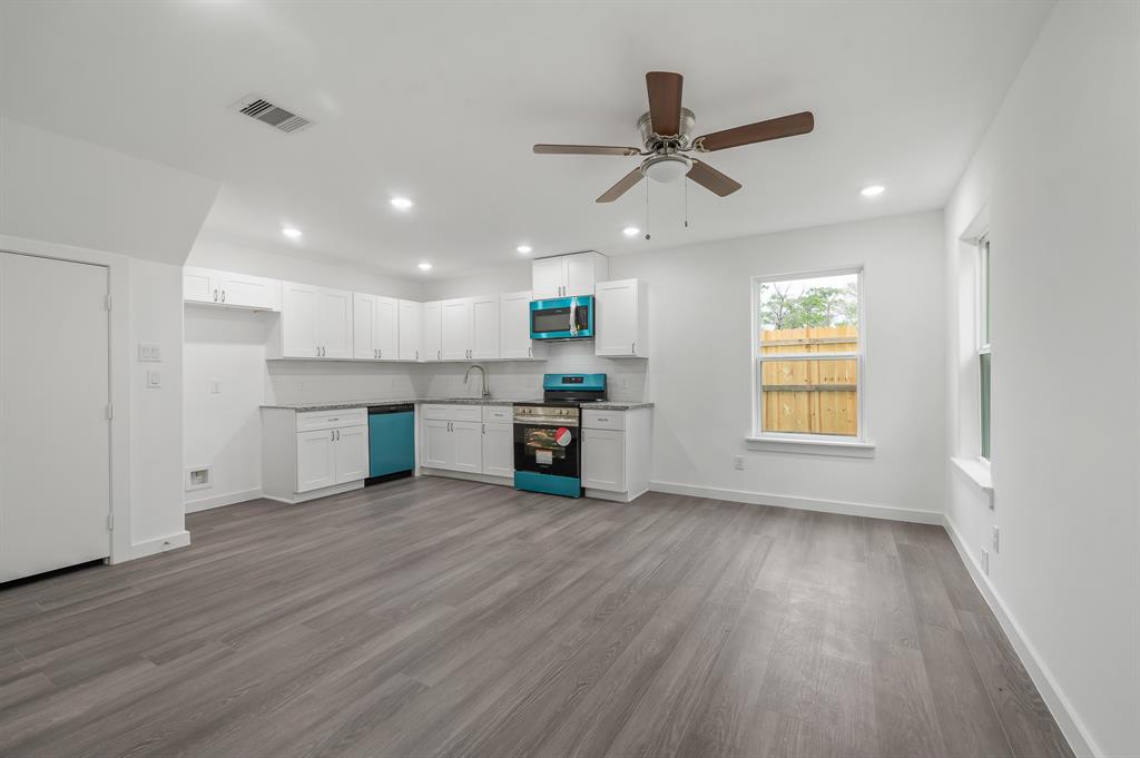 a view of a kitchen with a sink dishwasher cabinets and wooden floor