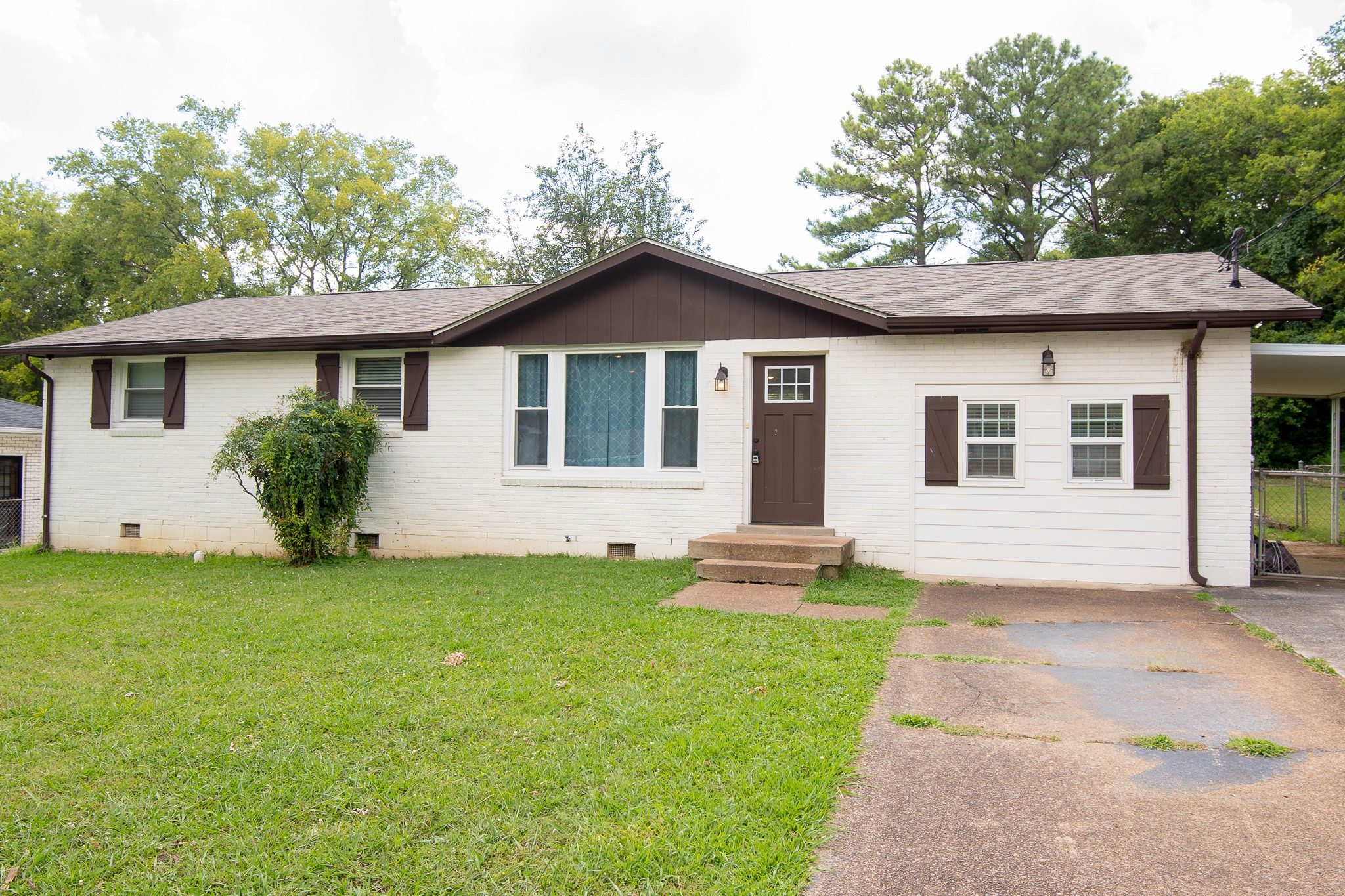 a front view of a house with a yard and trees