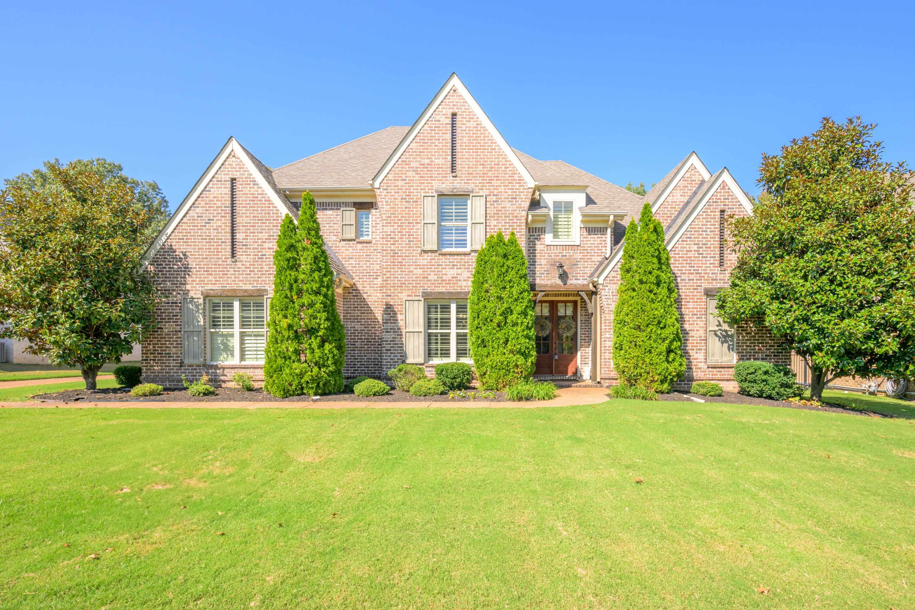 a front view of house with yard and green space