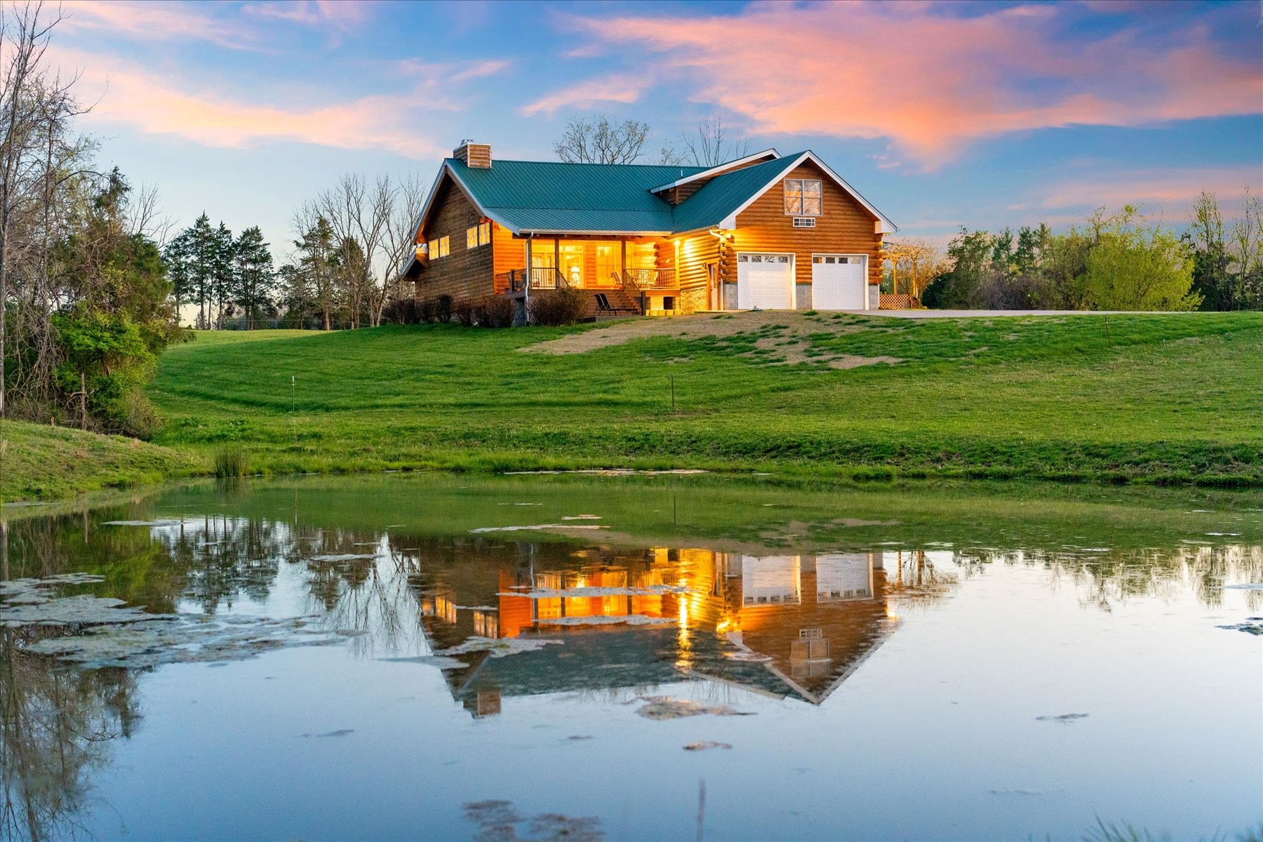 a front view of a house with a yard and lake view