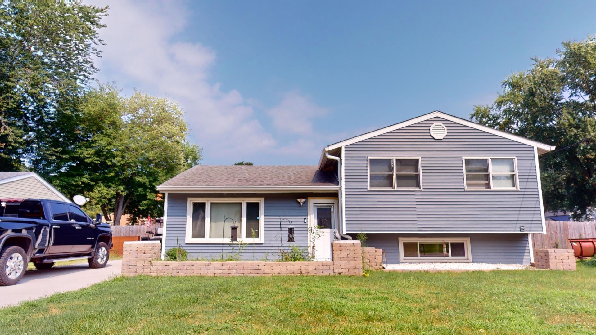 a front view of a house with a yard and trees