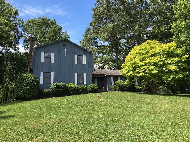 a front view of house with yard and trees