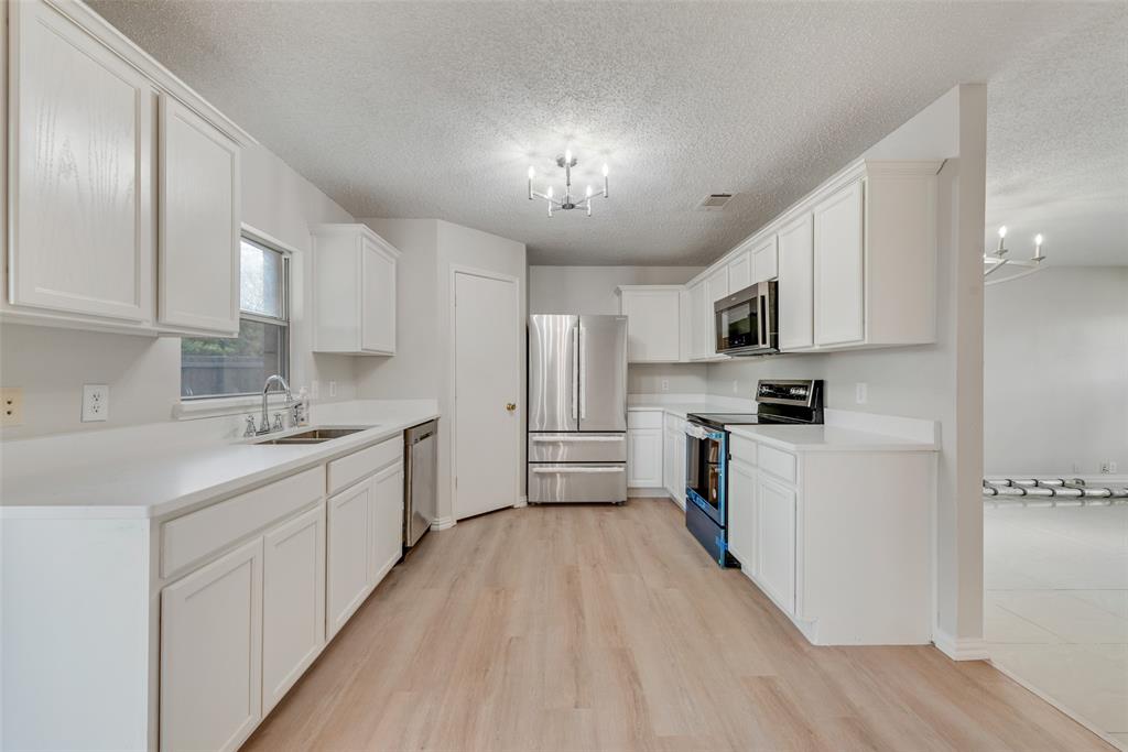 a kitchen with kitchen island granite countertop a sink a counter top space stainless steel appliances and cabinets